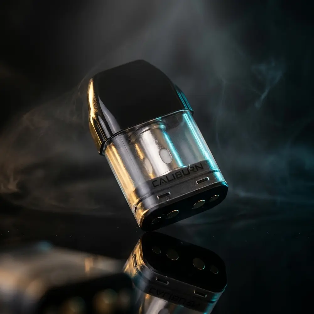 Pod reposicao Caliburn A2/A2S/AK2 Uwell sobre base acrilica com luzes quentes e frias e reflexos marcantes - Vapor Gringo