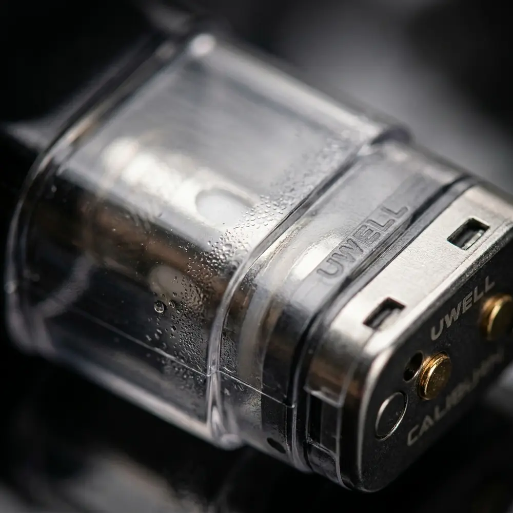 Detalhe do pod reposicao Caliburn Uwell mostrando transparencia, contatos metalicos e gotas de condensacao - Vapor Gringo