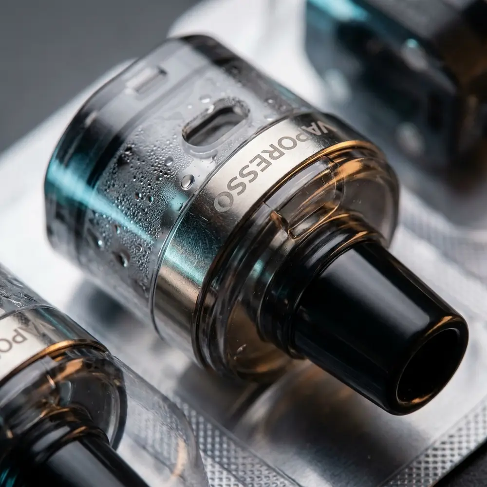 Macro do pod reposicao DTL para Luxe XR Vaporesso mostrando transparencia do tanque, anel metalico e gotas de condensacao - Vapor Gringo