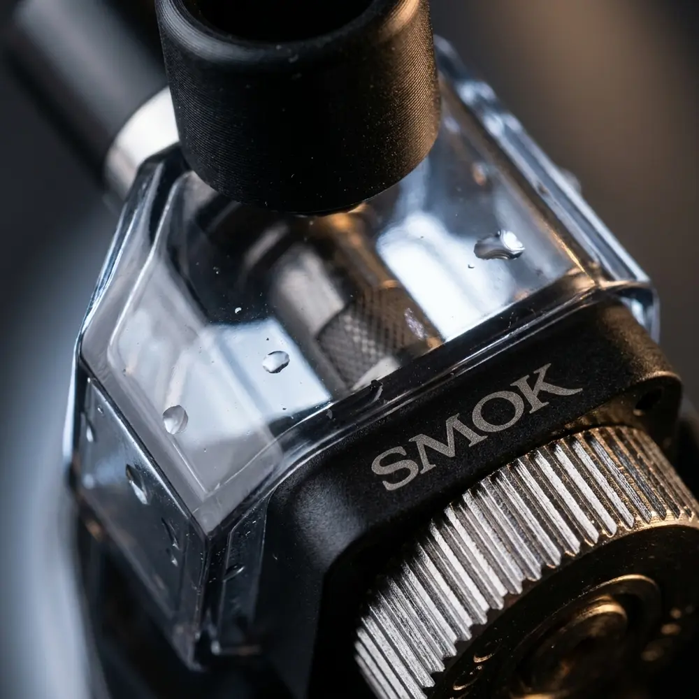 Detalhe da concha transparente, anel metálico e selo da marca do pod Fetch Pro 4ml com gotas de condensacao - Vapor Gringo