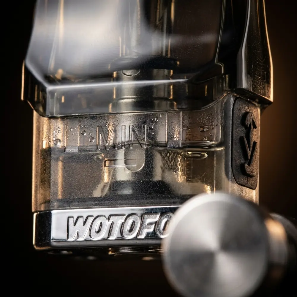 Close-up do cartucho Manik Mini 3ml mostrando conector magnetico, resistencia e goticulas na transparencia - Vapor Gringo