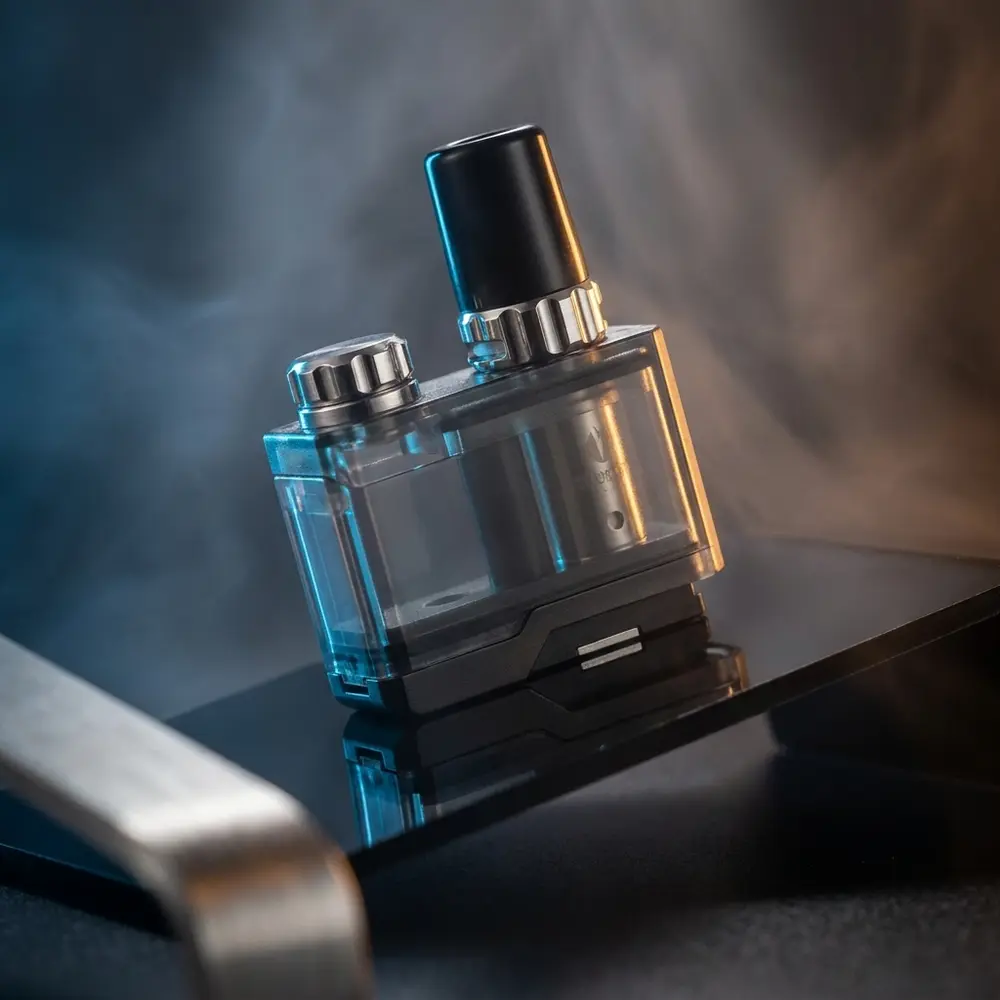 Pod Reposição Orion Plus Lost Vape apoiado em acrílico preto com luzes azul-âmbar e reflexos - Vapor Gringo