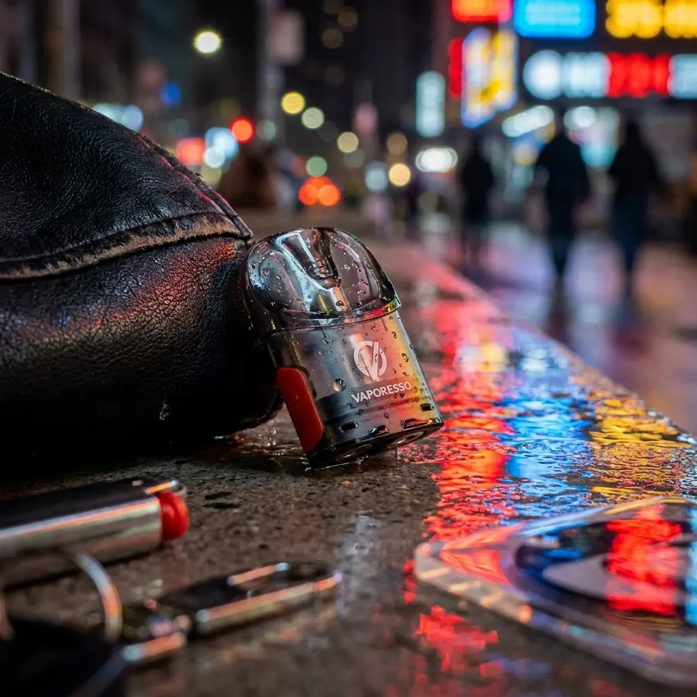 Pod Reposição Osmall 2 apoiado em parapeito urbano molhado com reflexos neon e cidade desfocada ao fundo - Vapor Gringo