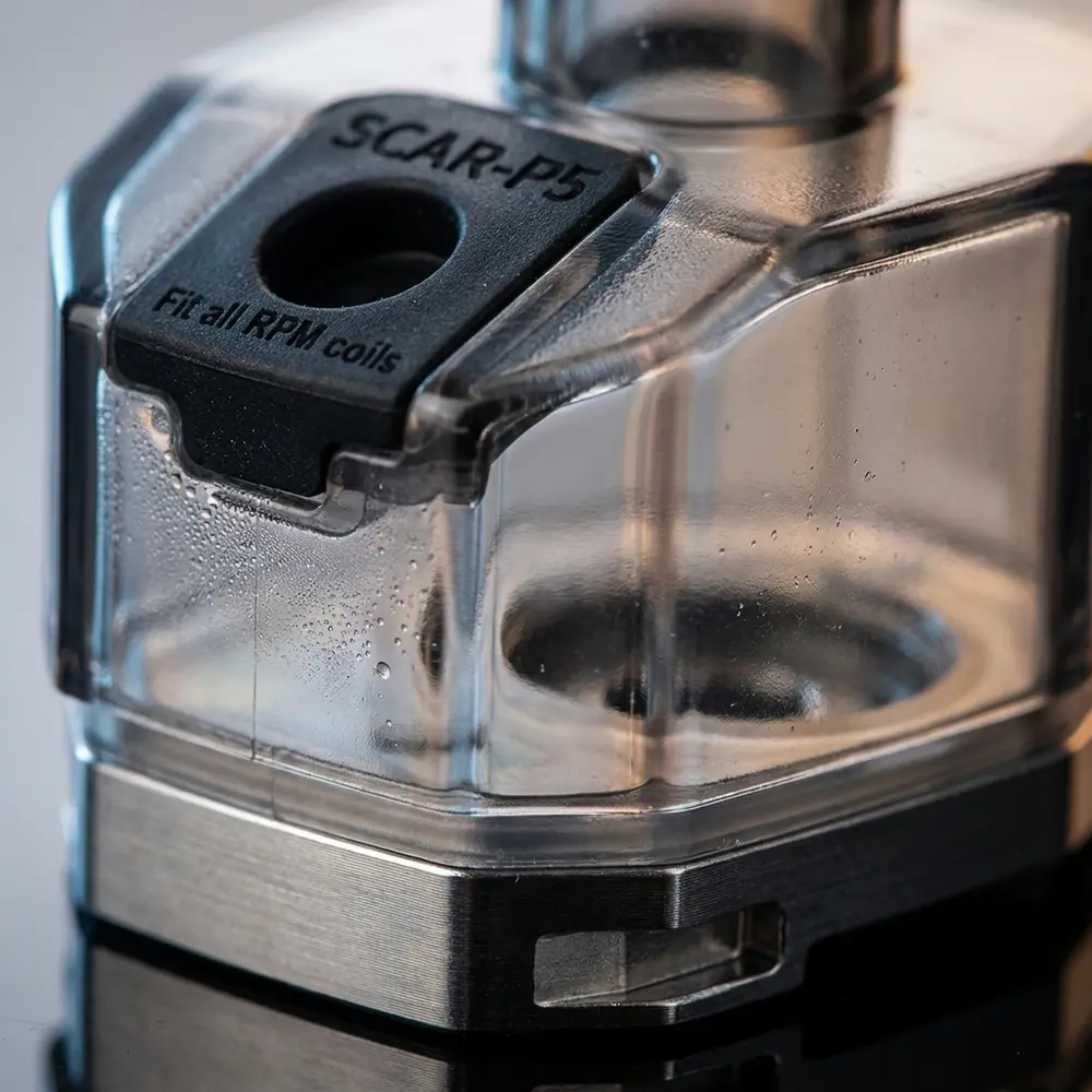 Macro do Pod Reposição Scar P5 RPM da Smok mostrando carcaça translúcida, metal e porta de enchimento - Vapor Gringo