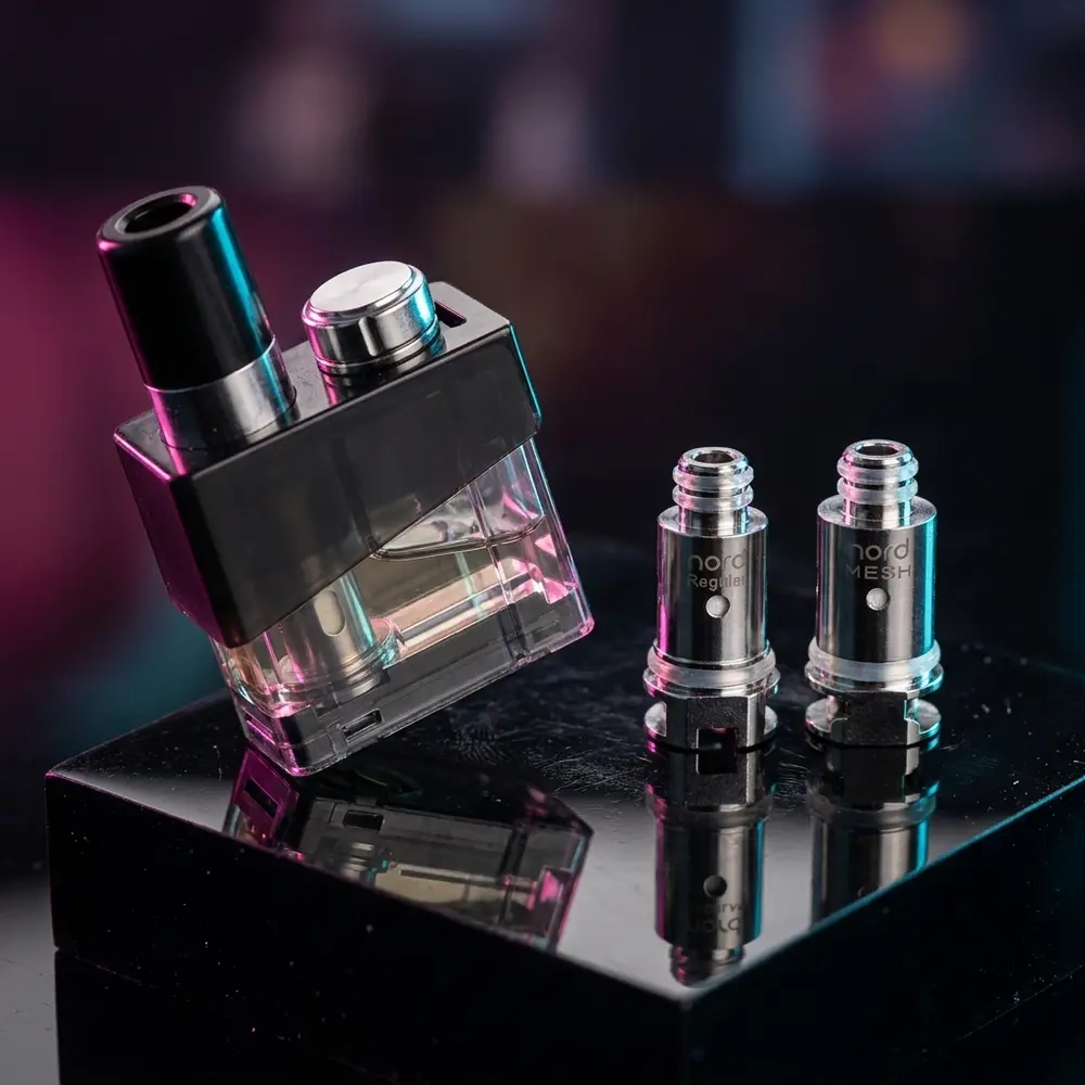 Pod Reposição Trinity Alpha da Smok apoiado em acrílico preto com reflexos prismáticos e tampa lateral visível - Vapor Gringo