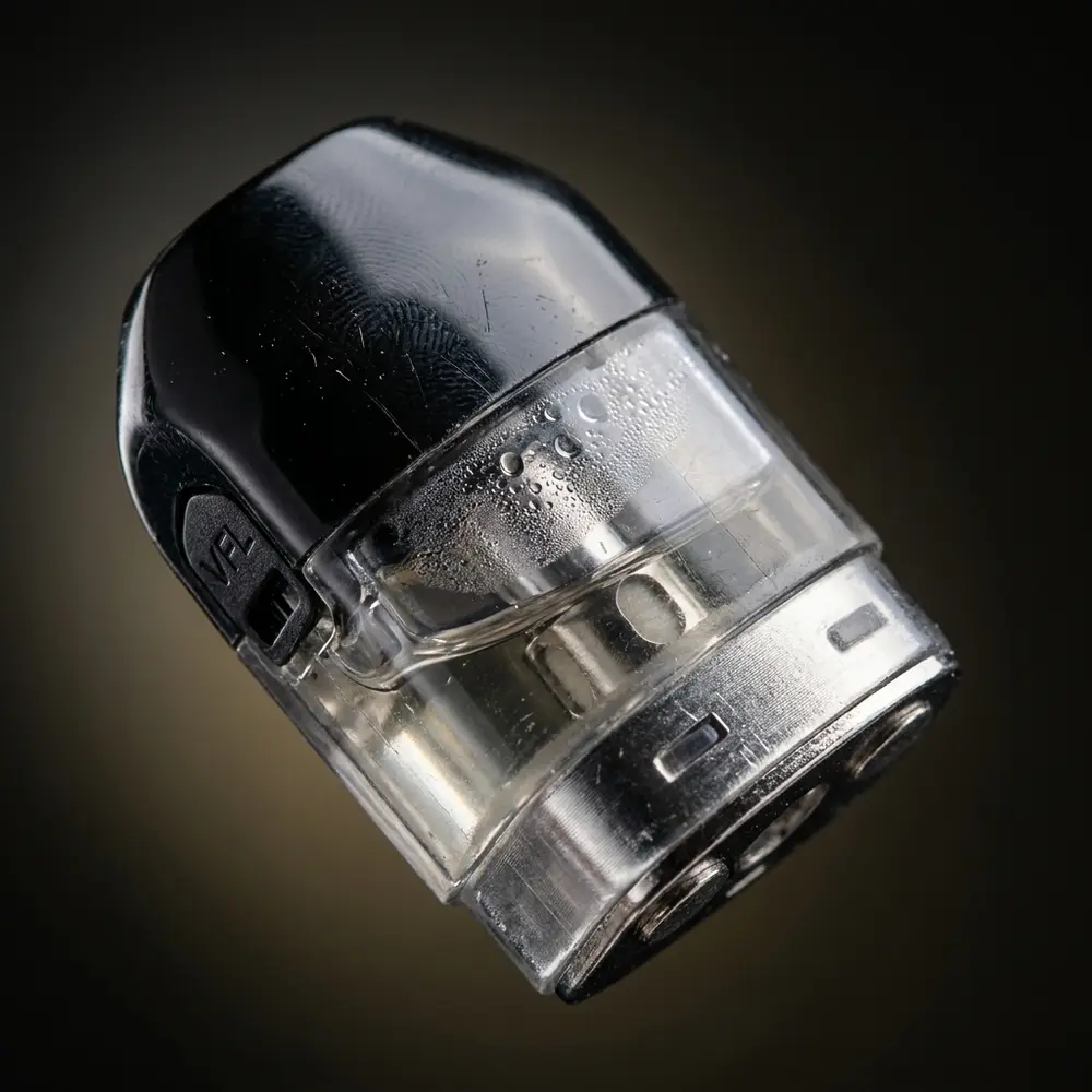 Macro do Pod Reposição VFL Voopoo mostrando carcaça transparente, contatos metálicos e gotículas - Vapor Gringo