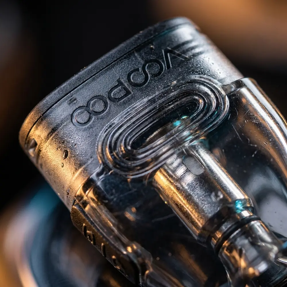 Close-up do Pod Reposição VMate Voopoo mostrando casco transparente, bobina metálica e gotículas de condensação - Vapor Gringo