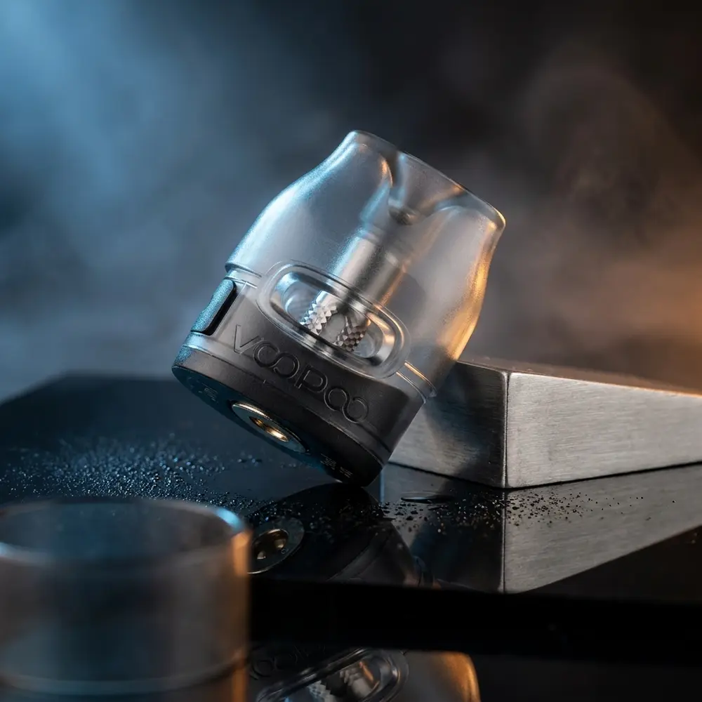 Pod reposição VTHRU 3ml Voopoo sobre base acrílica preta com reflexos azul e âmbar e nevoeiro suave - Vapor Gringo