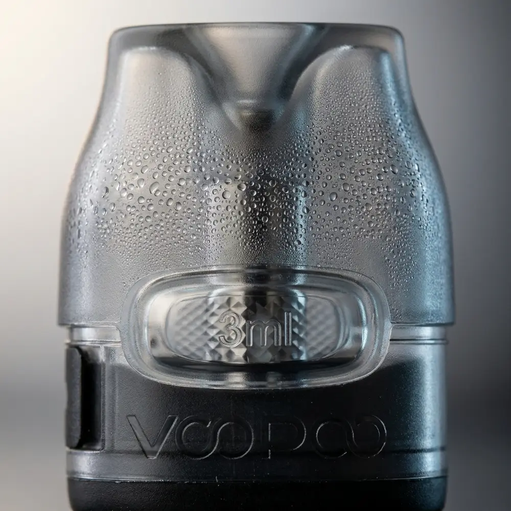 Close-up do pod VTHRU 3ml Voopoo mostrando bocal, bobina visível e gotículas de condensação na carcaça transparente - Vapor Gringo
