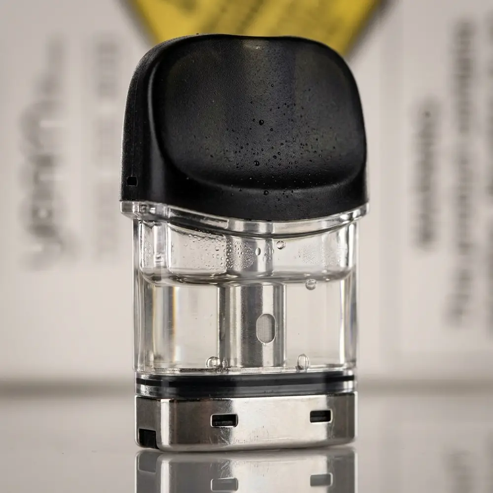 Macro do Pod Reposição Yearn Uwell mostrando câmara translúcida, contatos metálicos e gotas de condensação - Vapor Gringo