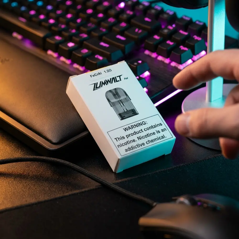 Pod Reposicao Zumwalt Uwell apoiado em mesa RGB de gaming, teclado iluminado ao fundo e cabo em primeiro plano - Vapor Gringo