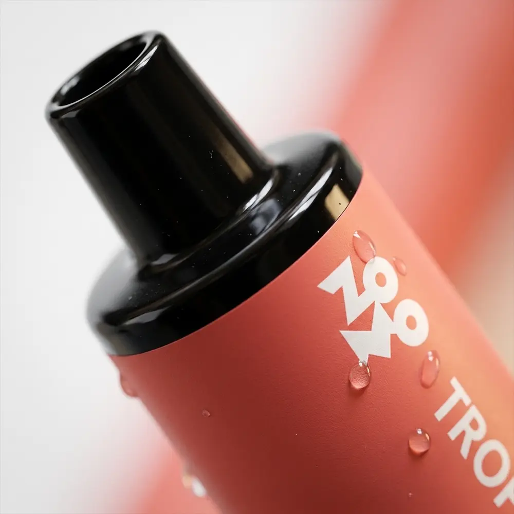 Close-up do Pod Zomo Flow Tropical Fruit mostrando bocal, etiquetas e gotas de condensação com textura - Vapor Gringo