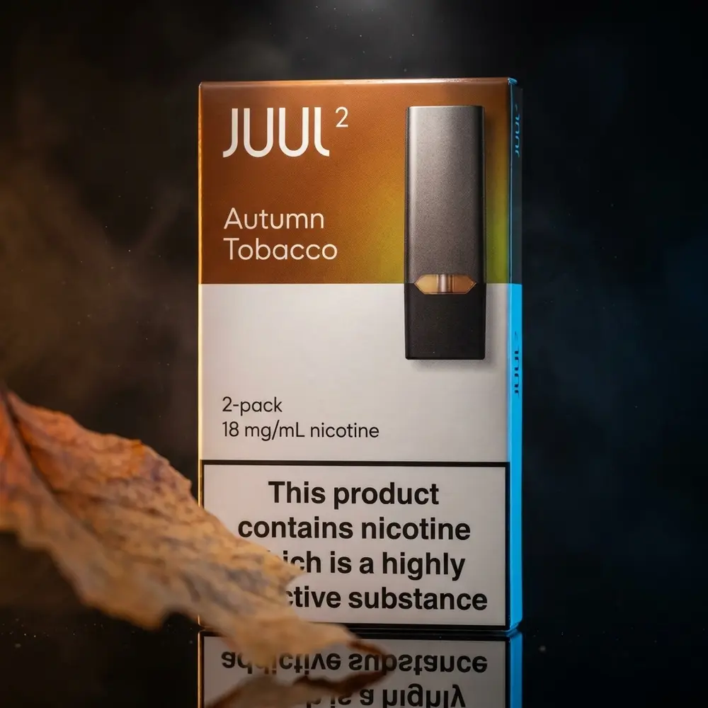 Refil Pod Juul 2 Autumn Tobacco em close sobre acrílico preto, reflexos quentes e iluminação outonal sofisticada - Vapor Gringo