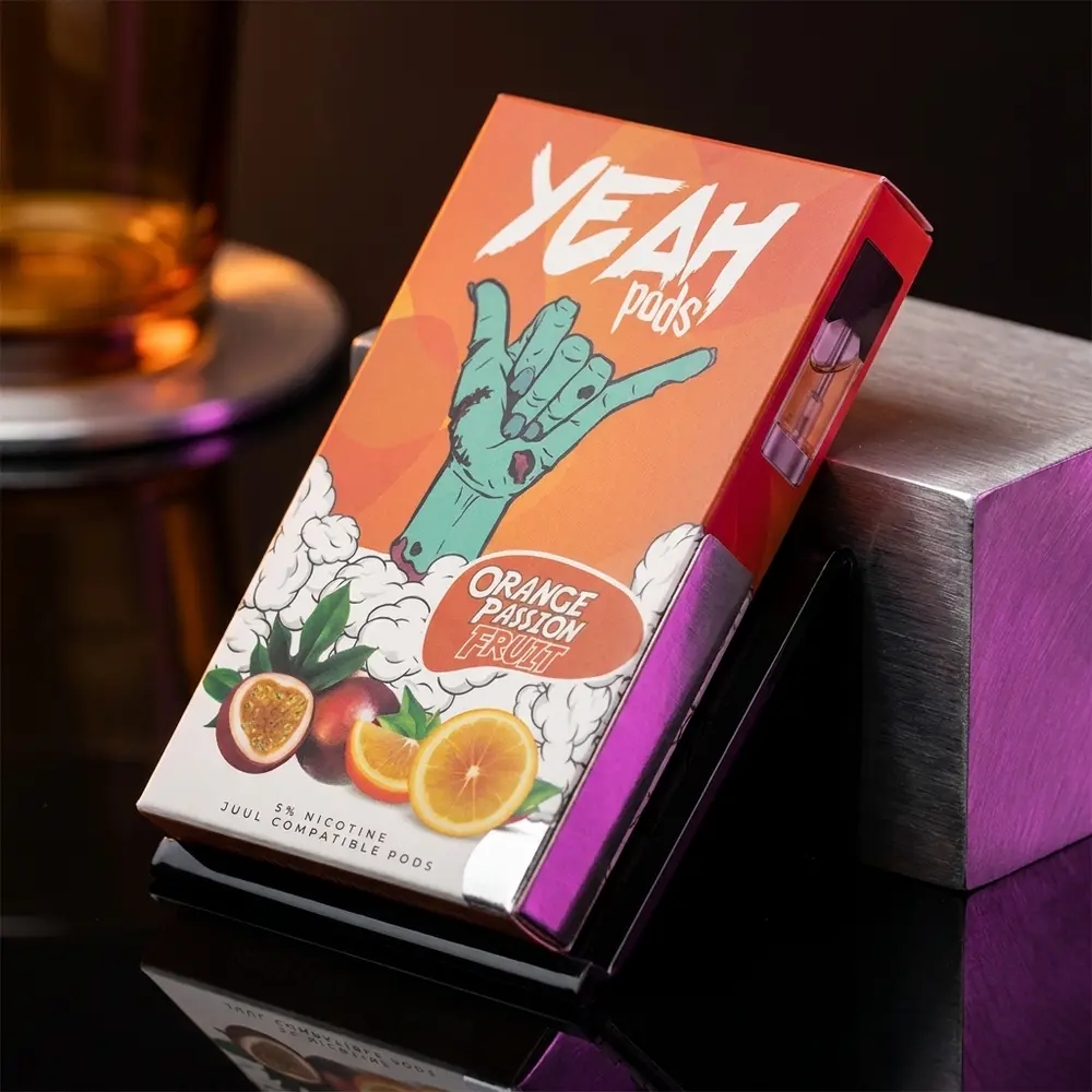 Refil para Pod Juul Yeah Orange Passion Fruit apoiado em acrílico preto brilhante com luz laranja e reflexos metálicos - Vapor Gringo