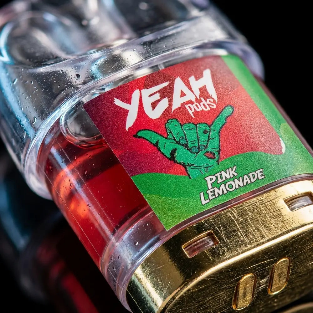 Detalhe macro do refil para Pod Juul Yeah Pink Lemonade mostrando transparência, contatos metálicos e gotículas - Vapor Gringo