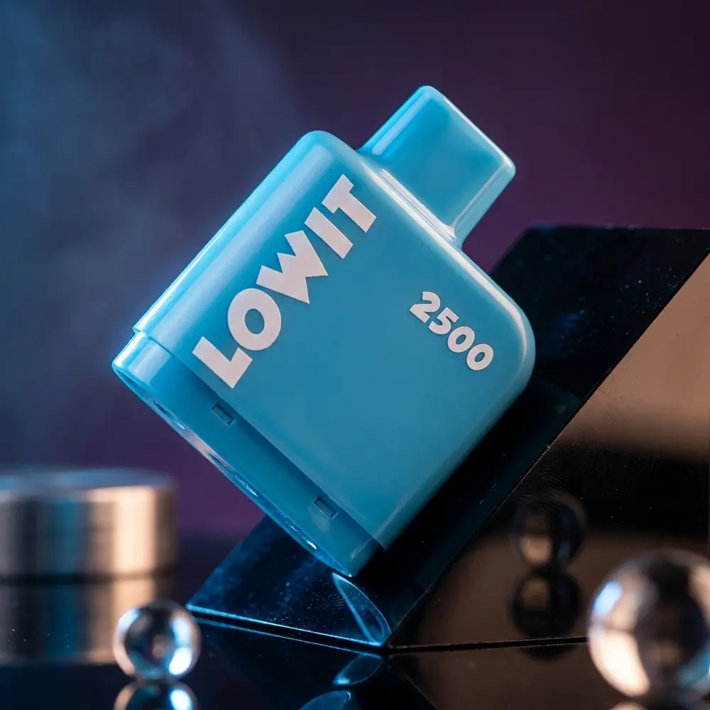 Refil Pod Lowit 2500 Blue Razz Ice apoiado em acrilico molhado com luzes neon azuis e magenta ao fundo - Vapor Gringo