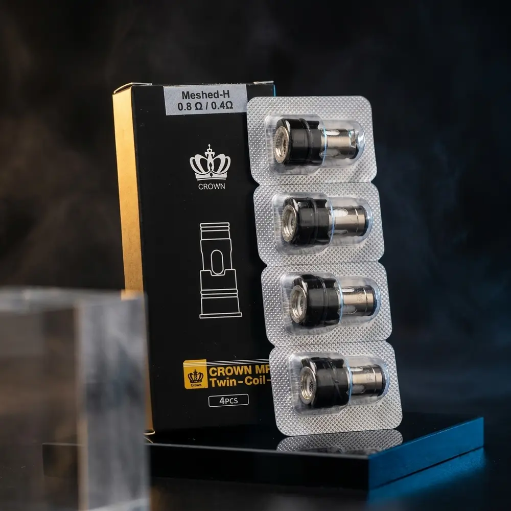 Resistência Coil Crown M da Uwell sobre acrílico preto com iluminação dramática, reflexos e gotas - Vapor Gringo