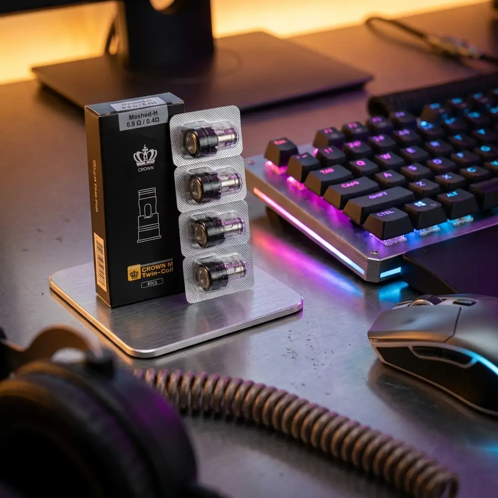 Resistência Coil Crown M da Uwell em bancada gamer com iluminação RGB, teclado mecânico e reflexos metálicos - Vapor Gringo