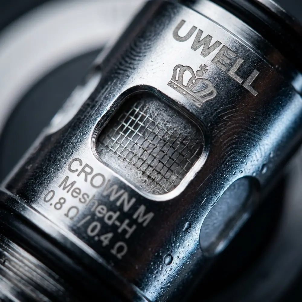 Detalhe da Resistência Coil Crown M Uwell mostrando mesh, gravações, textura metálica e condensação - Vapor Gringo