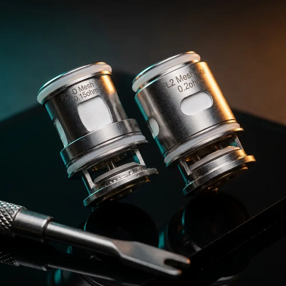 Resistência Coil FL para Maxus Solo Freemax inclinada sobre acrílico preto com luzes teal e âmbar - Vapor Gringo