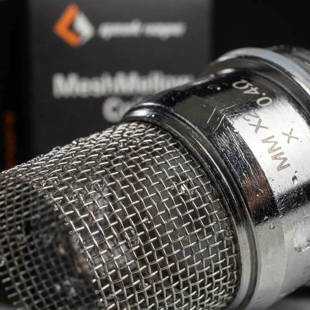 Close-up da malha Kanthal da Resistência Coil Meshmellow com gotas, texturas metálicas e rótulo ao fundo - Vapor Gringo