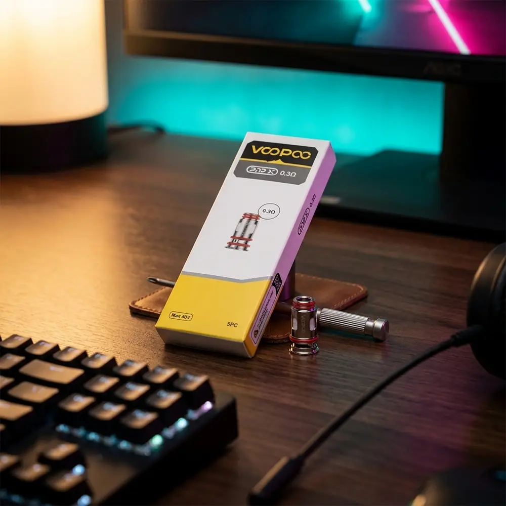 Pack da Resistencia Coil PnP X Voopoo sobre mesa gamer com teclado mecanico, monitor desfocado e luzes RGB - Vapor Gringo