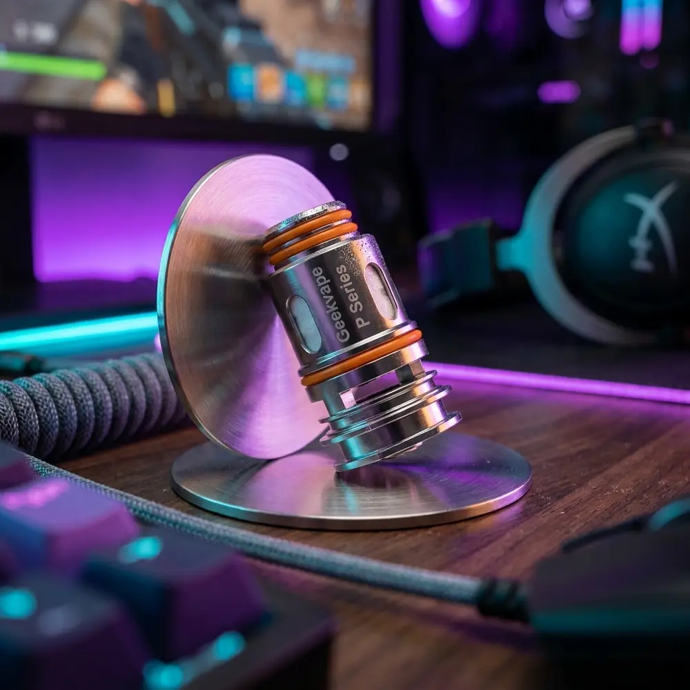 Resistência Coil Série P apoiada em mesa gamer RGB, teclado desfocado e luzes neon ao fundo. - Vapor Gringo