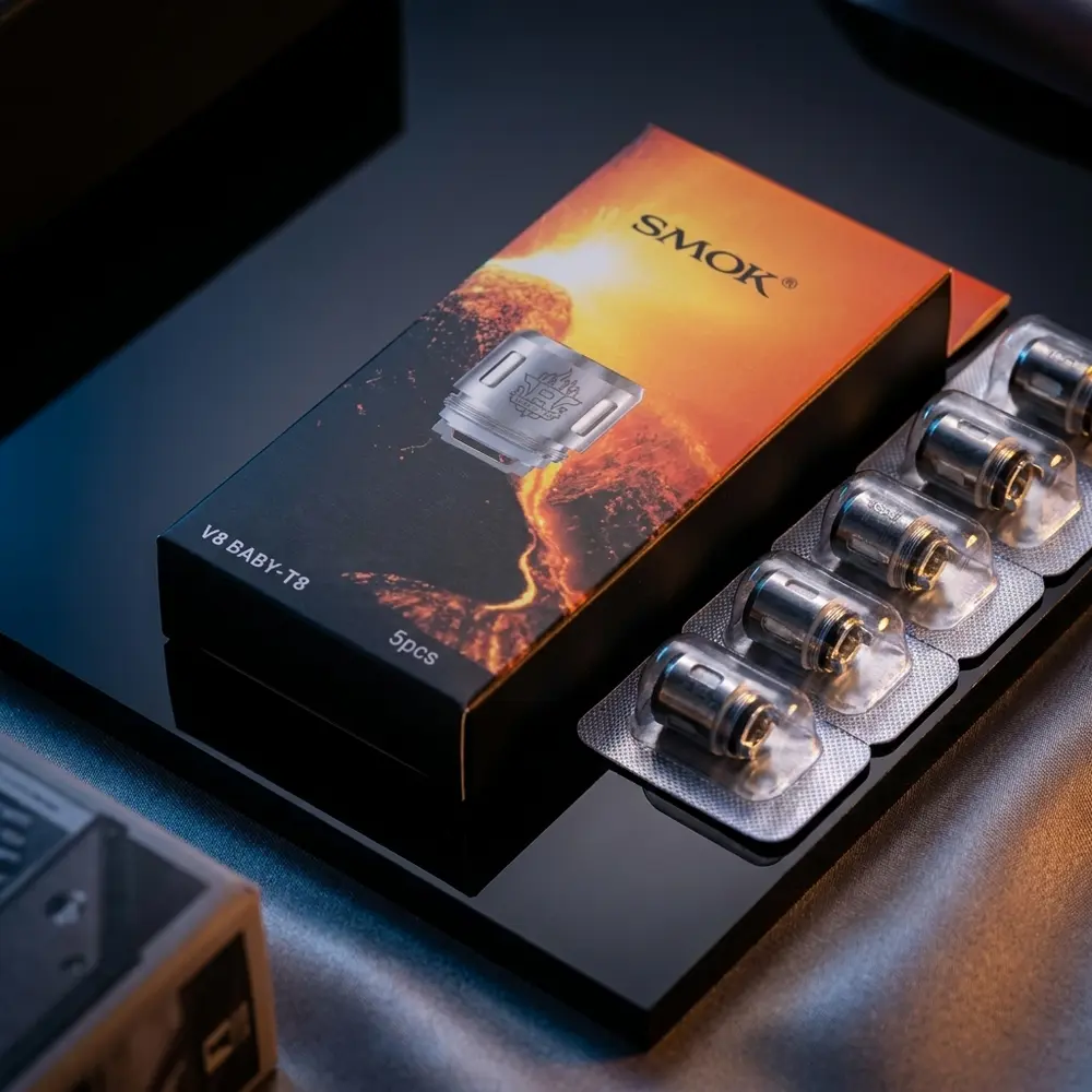Resistência Coil T8 Smok em embalagem sobre acrílico preto, iluminação dramática e reflexos luxuosos - Vapor Gringo