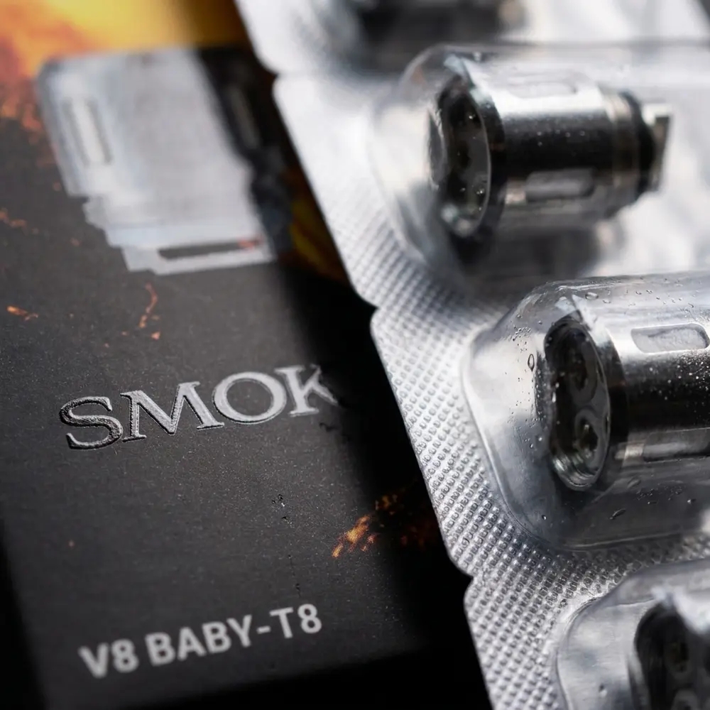 Detalhe macro da embalagem da Resistência Coil T8 Smok, textura do verniz, tipografia e reflexos metálicos - Vapor Gringo