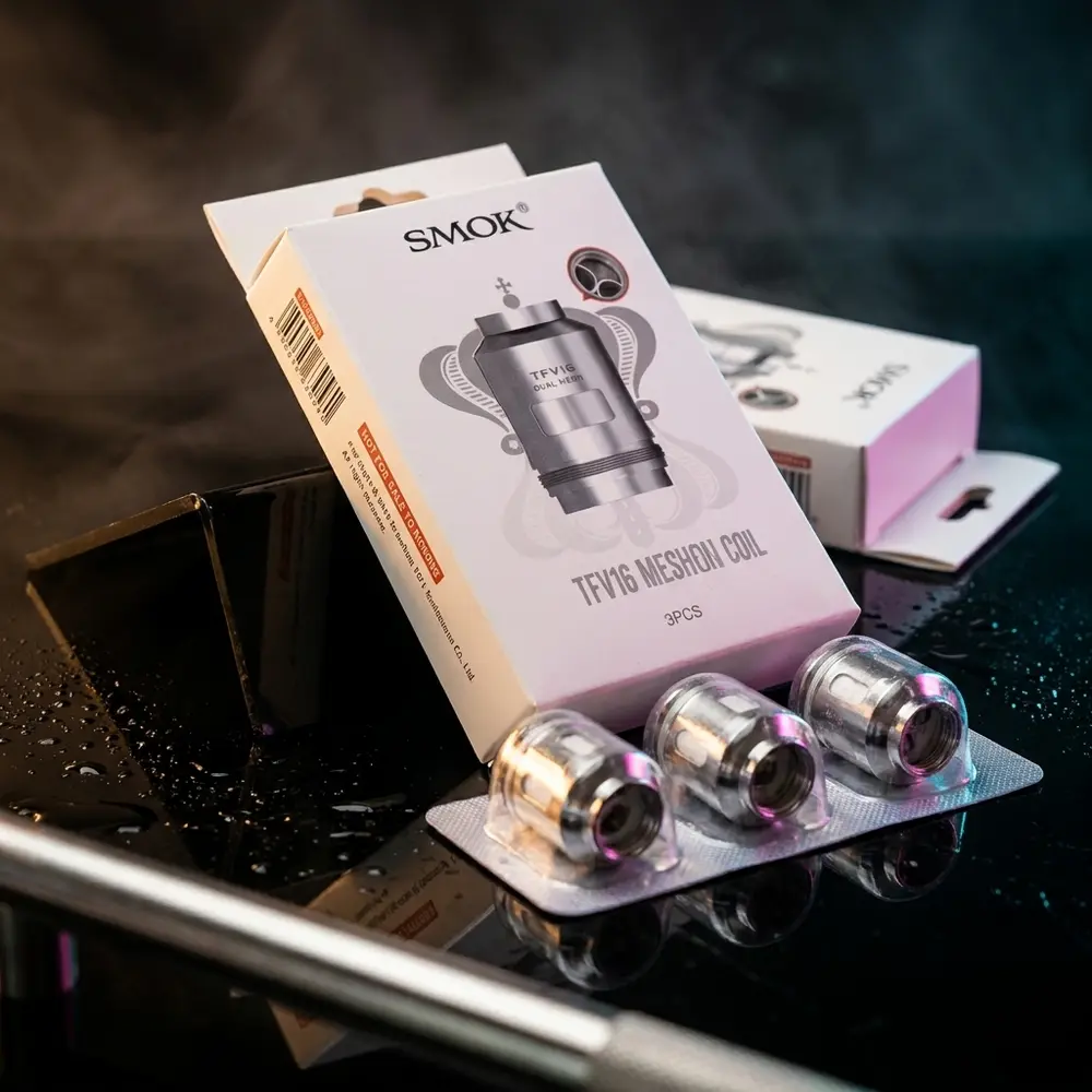 Resistência Coil TFV16 da Smok apoiada em acrílico preto com luzes RGB e reflexos metálicos - Vapor Gringo