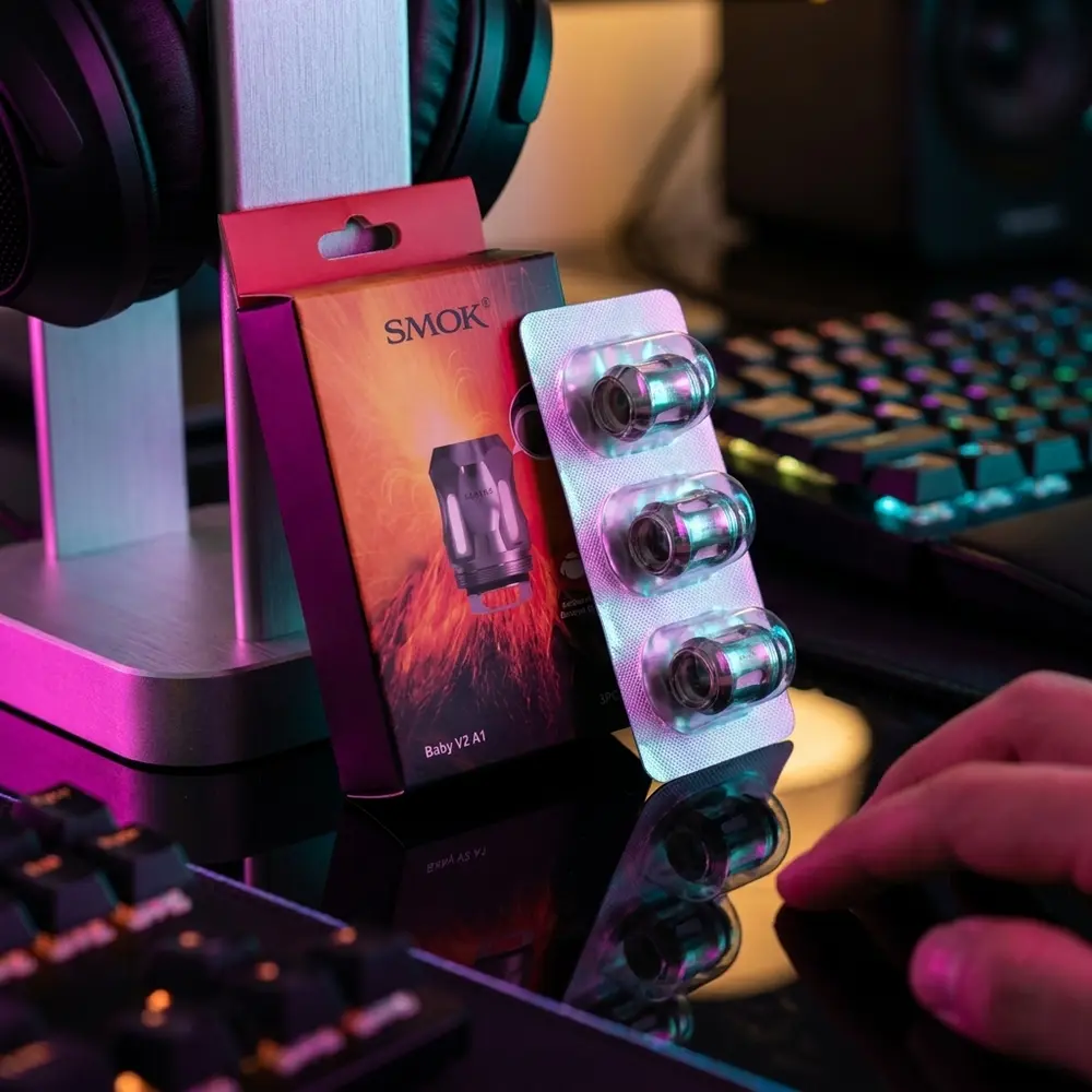 Pack de resistência TFV8 BABY V2 A1 Smok sobre mesa gamer RGB com teclado mecânico e reflexos neon - Vapor Gringo