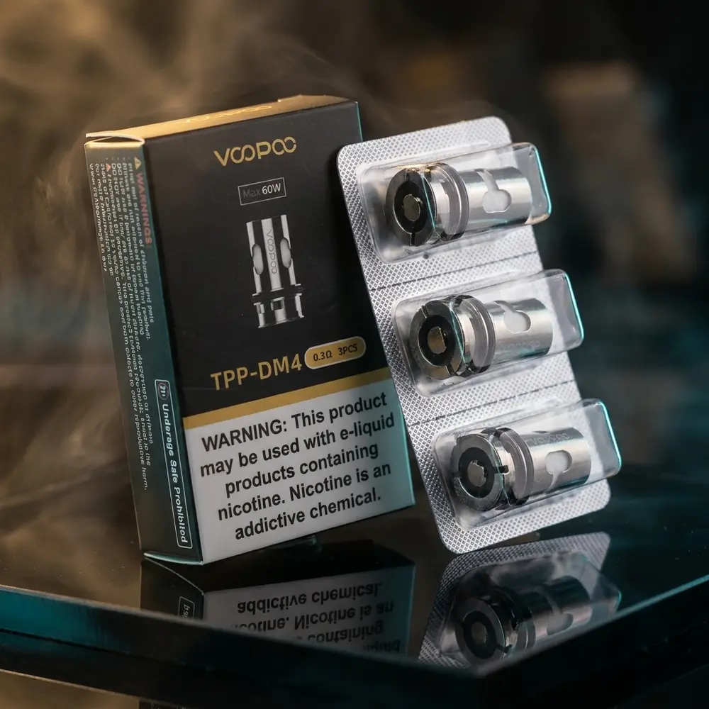 Pacote de coil TPP-DM4 Voopoo inclinado sobre acrilico preto com luzes quentes e reflexos frios - Vapor Gringo