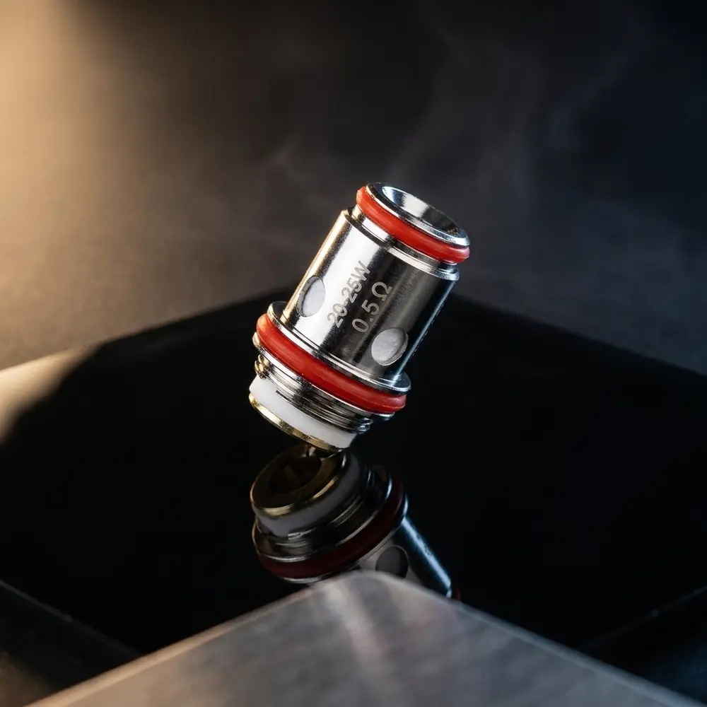 Resistência Coil Unicoil 1.0ohm OXVA apoiada em acrílico preto brilhante com iluminação quente e reflexos metálicos - Vapor Gringo