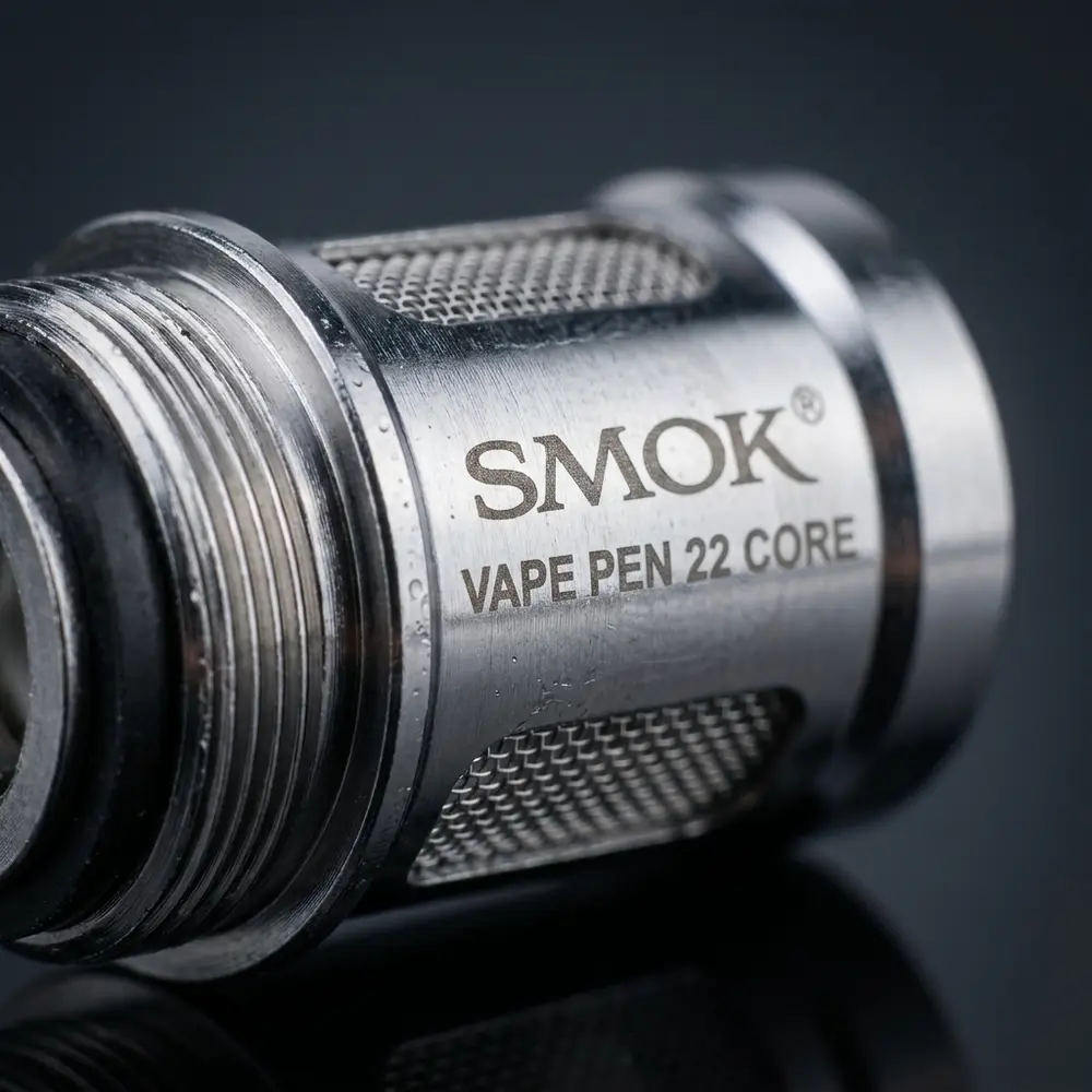 Detalhe macro da Resistência Coil Vape Pen 22 e Pen V2 da Smok mostrando metal, malha e textura com gotas - Vapor Gringo