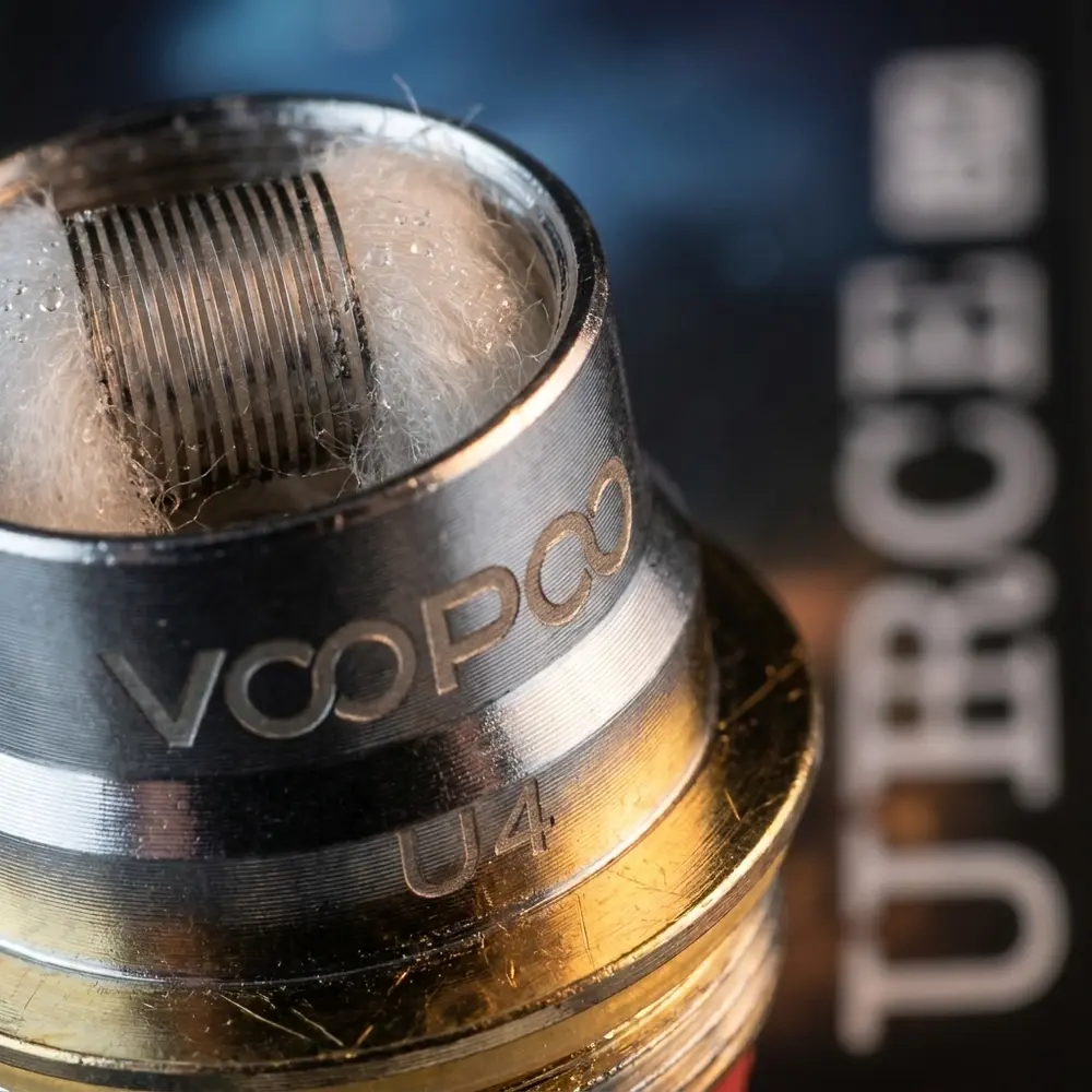 Close-up da resistência Coil Voopoo Uforce mostrando conexão banhada a ouro, malha e algodão - Vapor Gringo