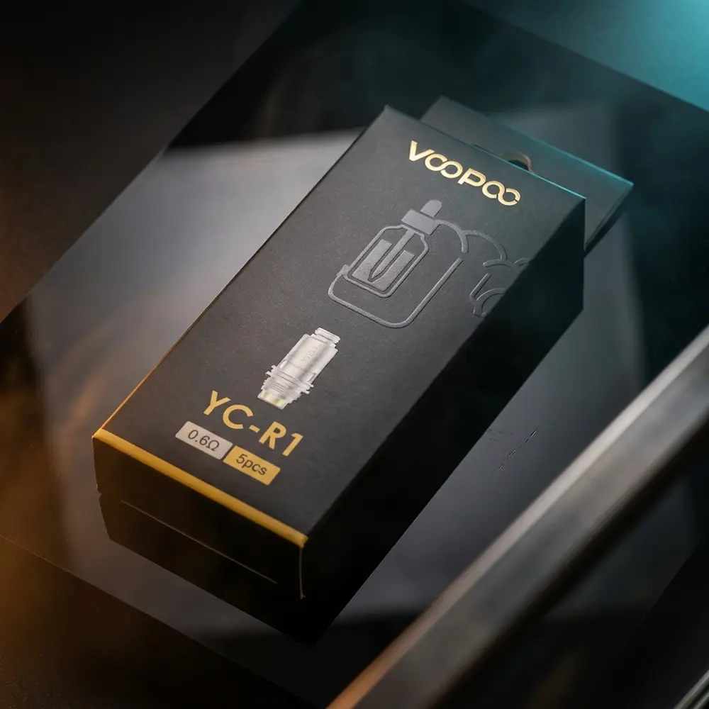 Resistência Coil YC-R1 Voopoo sobre placa acrílica preta com luzes azul e âmbar iluminando a embalagem - Vapor Gringo