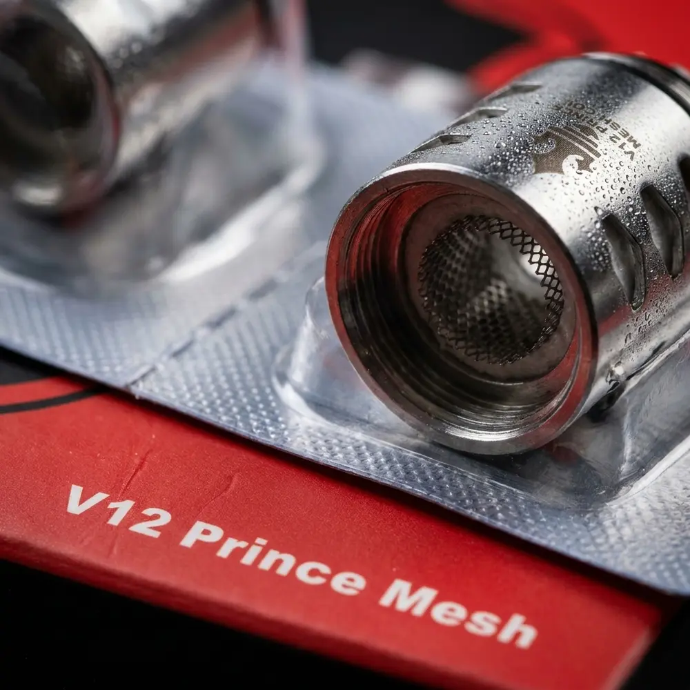 Close extremo da Resistência Mesh TFV12 Prince da Smok mostrando malha metálica, textura da embalagem e gotas de condensação. - Vapor Gringo