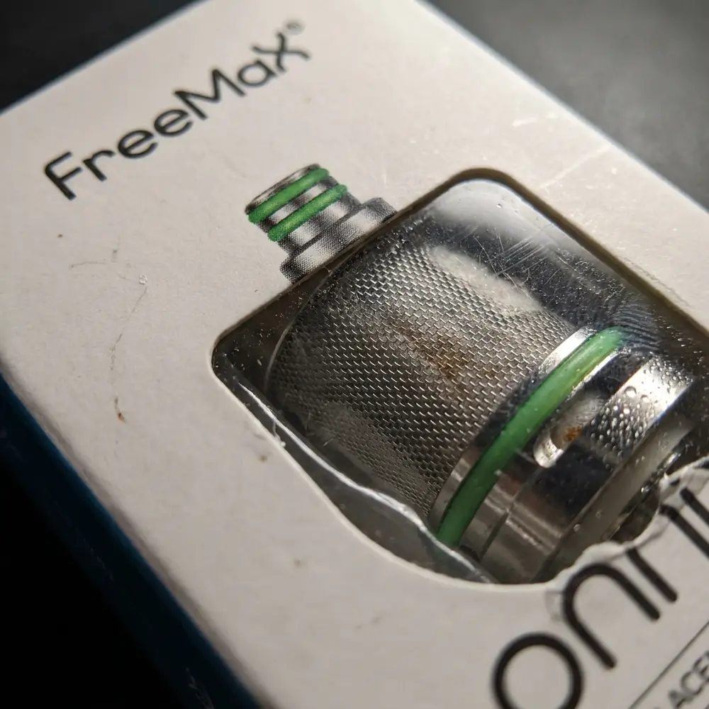 Close-up da Resistência OX Mesh 0.5 ohm Freemax mostrando malha SS904L, fibras e goticulas de condensacao - Vapor Gringo