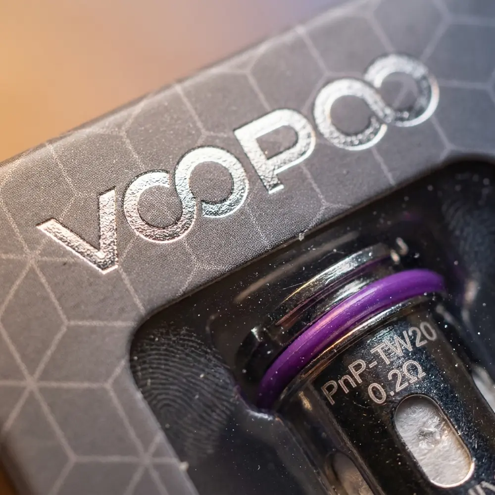 Macro da Resistência PnP Voopoo mostrando malha, acabamento metálico, texto impresso e gotas de condensação - Vapor Gringo