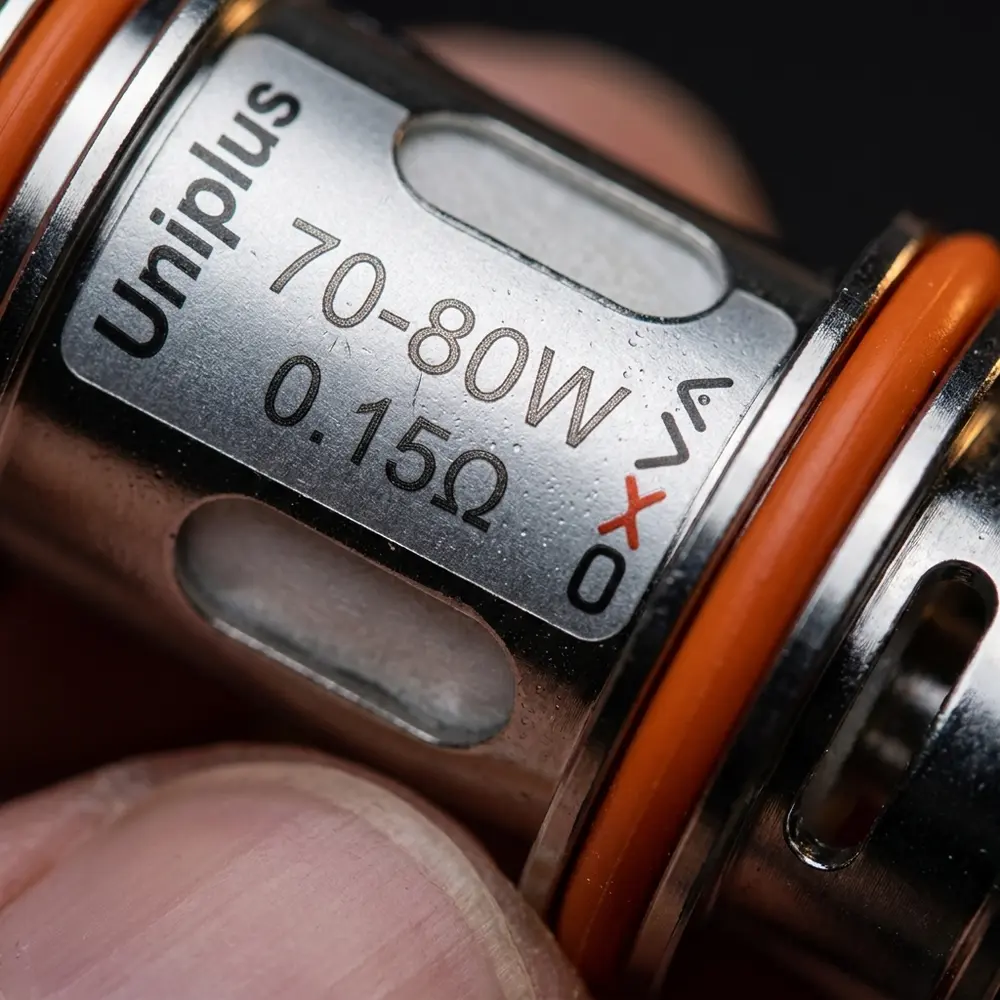 Detalhe macro da embalagem da Resistência Uniplus 0.15 ohm OXVA, rótulo, texturas, condensação e reflexos - Vapor Gringo