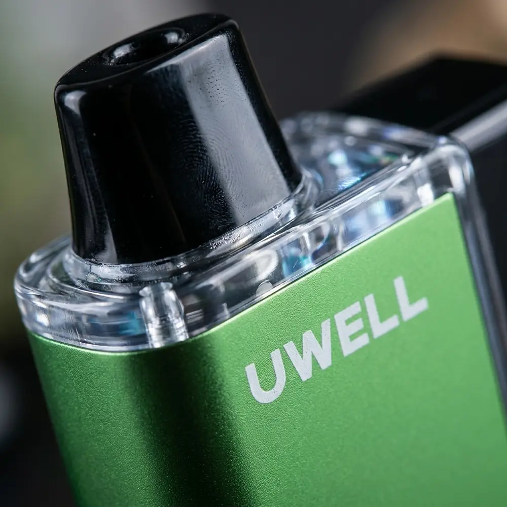Macro do Uwell DL8000 Sunny Grape mostrando logo, bocal, textura metalica e gotas de condensacao - Vapor Gringo