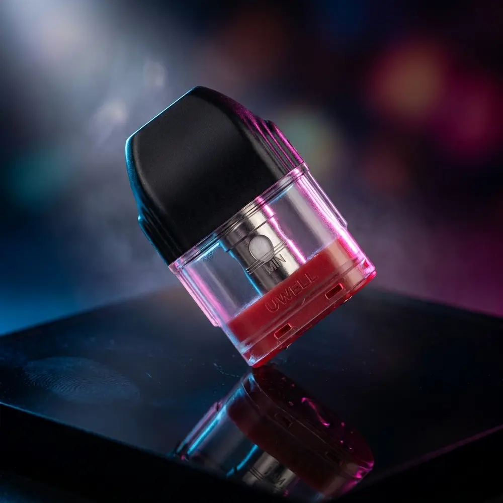 Pod de reposição Uwell KoKo Caliburn suspenso sobre base acrílica com iluminação azul-magenta - Vapor Gringo