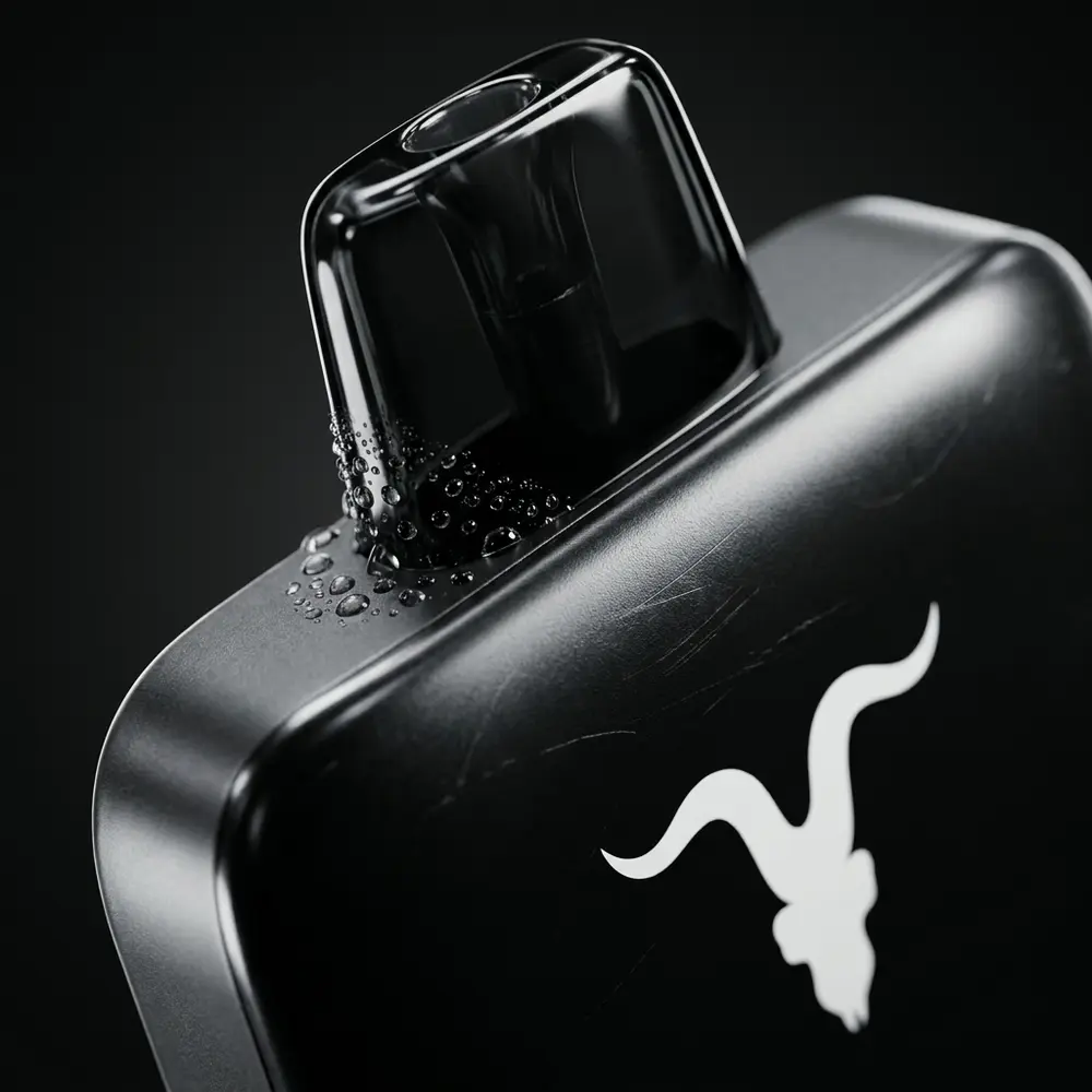 Detalhe do bocal e logo do Pod V55 Ultra Slim Ignite com gotas de condensacao e reflexos metalicos - Vapor Gringo