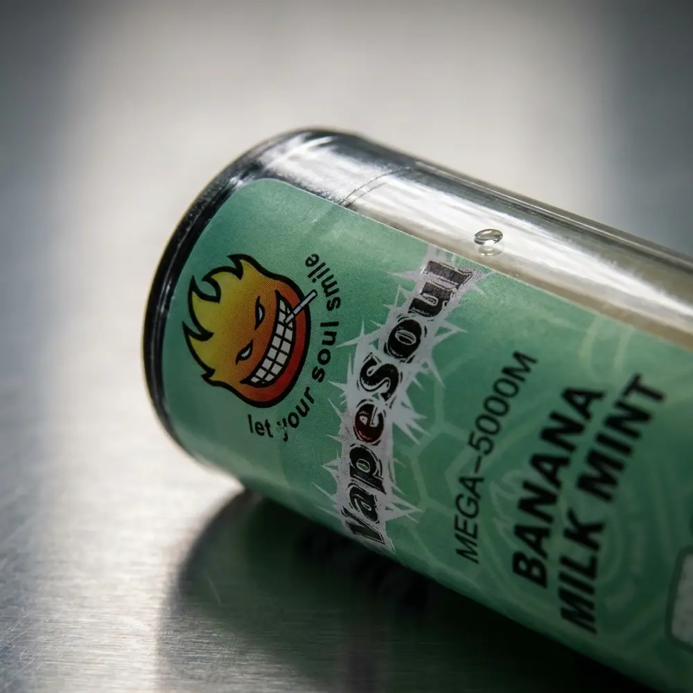 Close-up do bocal e rótulo do Vapesoul Mega Banana Milk Mint mostrando texturas e reflexos metallicos - Vapor Gringo