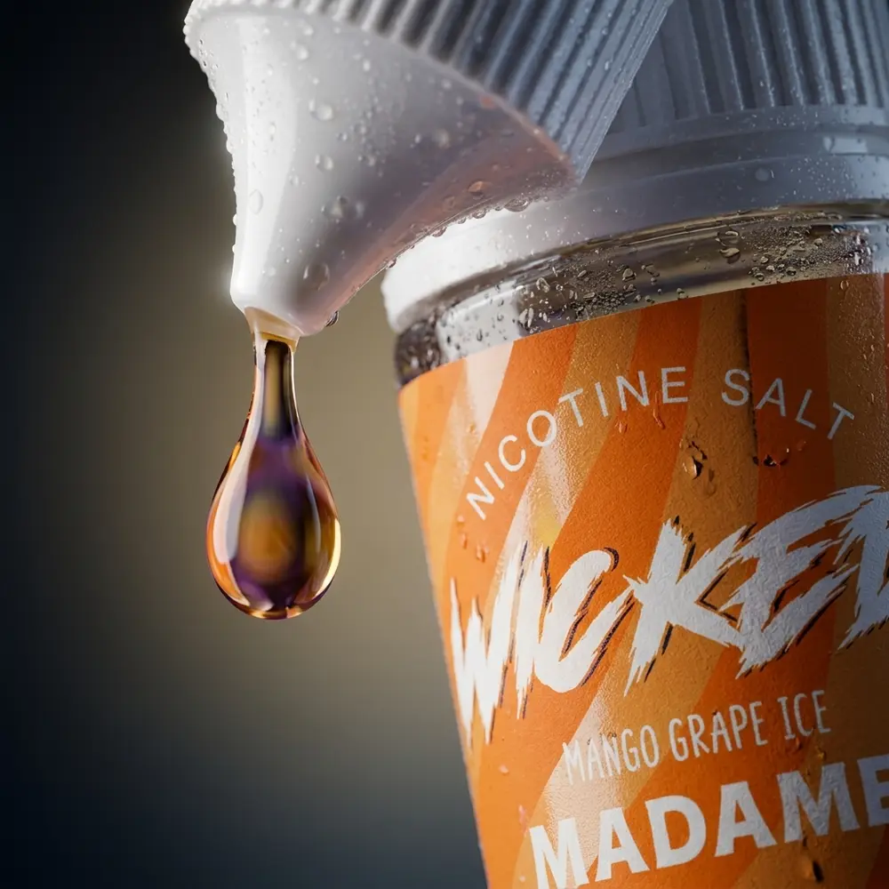 Close-up do frasco Wicked Salt Mango Grape Ice Madame com nozzle, gota pendente e condensacao no rotulo. - Vapor Gringo