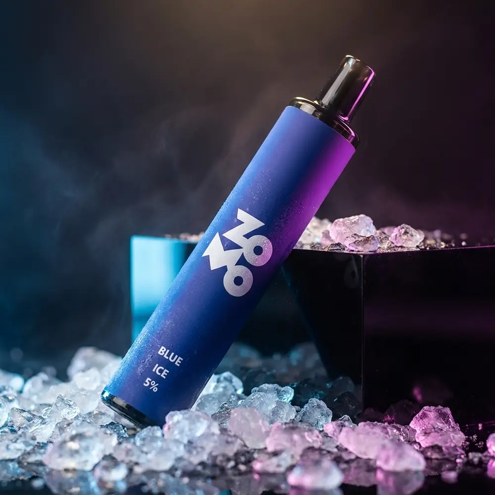 Pod descartavel Zomo Flow Blue Ice apoiado em acrilico com gelo e iluminacao azul, close cinematografico - Vapor Gringo