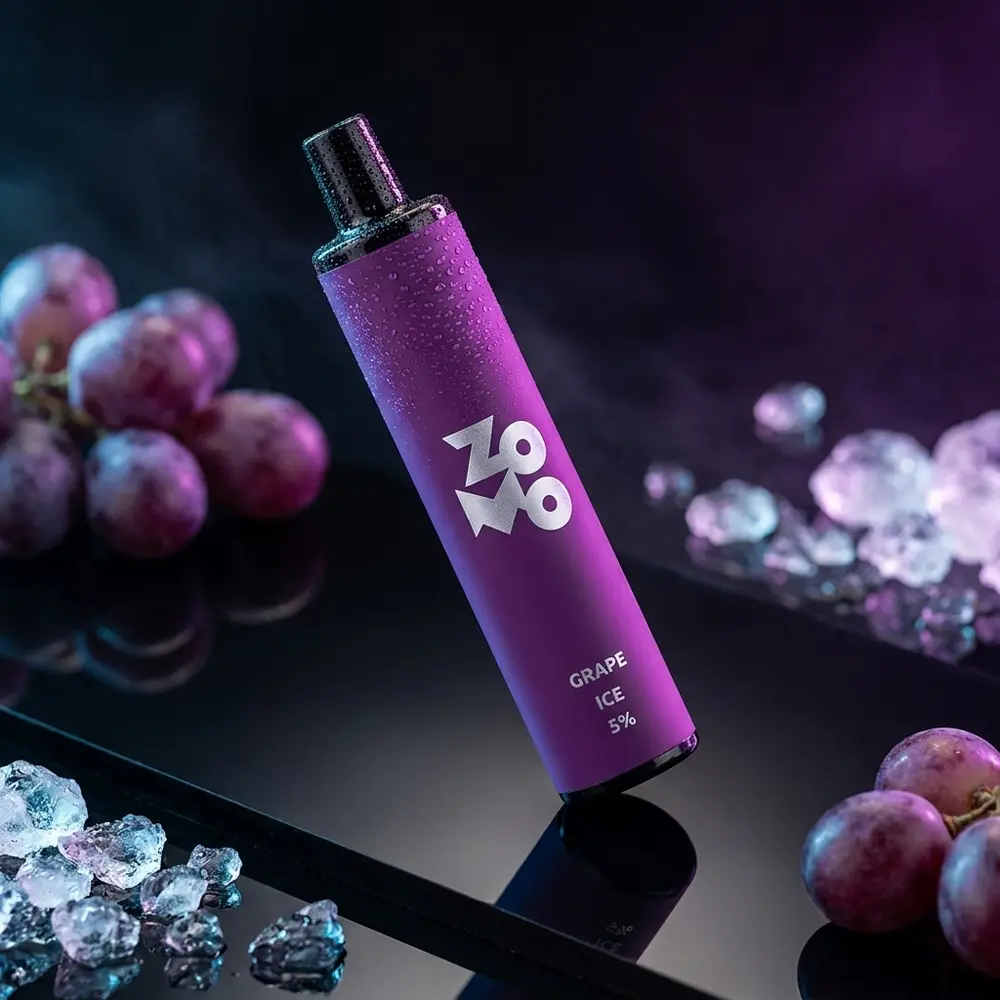Pod descartável Zomo Flow Grape Ice em close sobre acrílico preto, luzes roxas e azuis, gotas de condensação e reflexos - Vapor Gringo