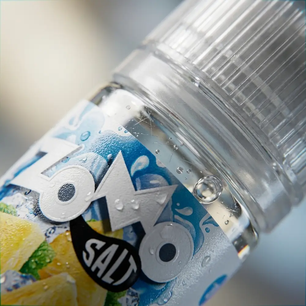 Macro do rótulo Zomo Salt Pineapple Ice mostrando tipografia, gotas de condensação e textura do vidro - Vapor Gringo