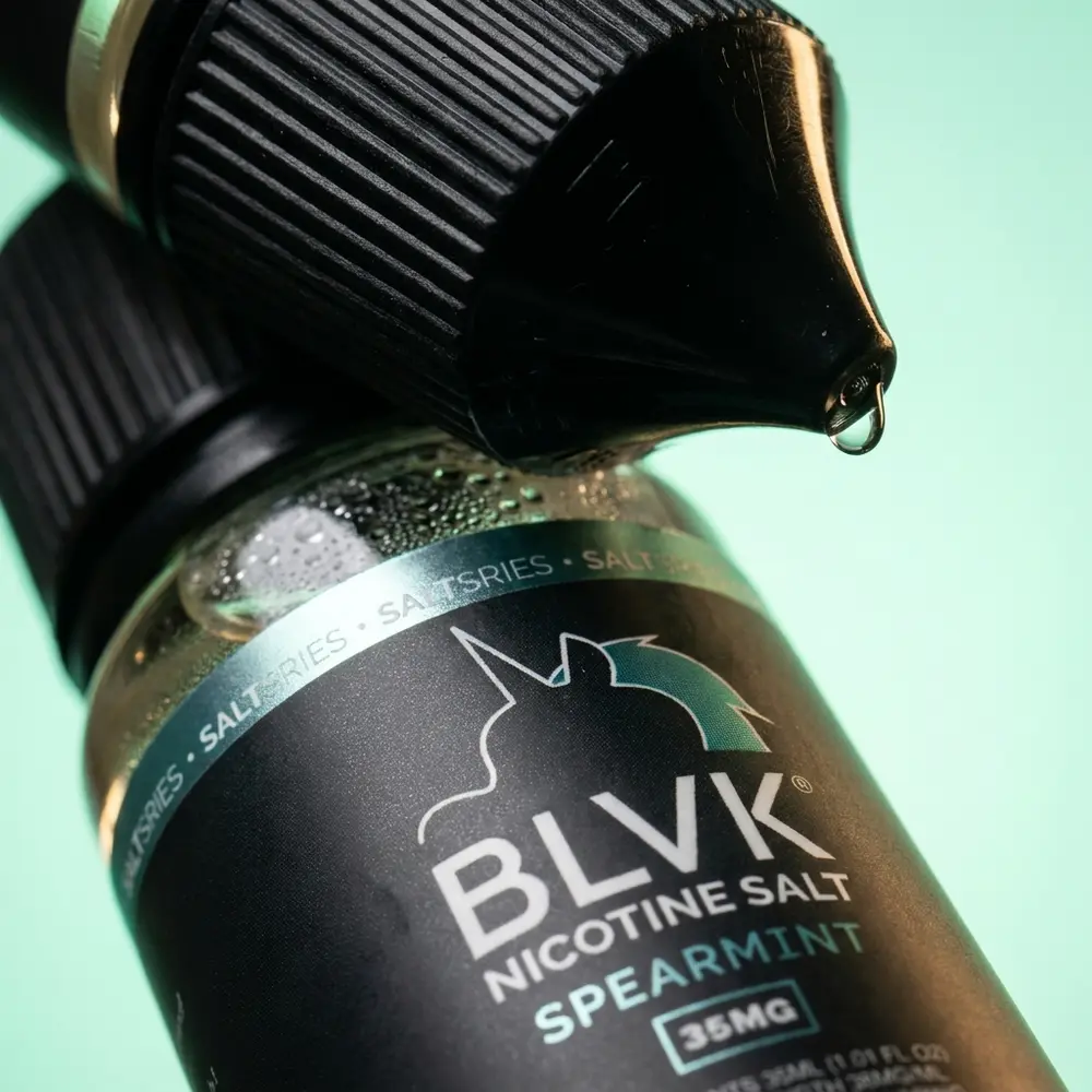 Macro do rotulo Blvk Unicorn Spearmint mostrando textura, gotas e detalhe do bico em close - Vapor Gringo