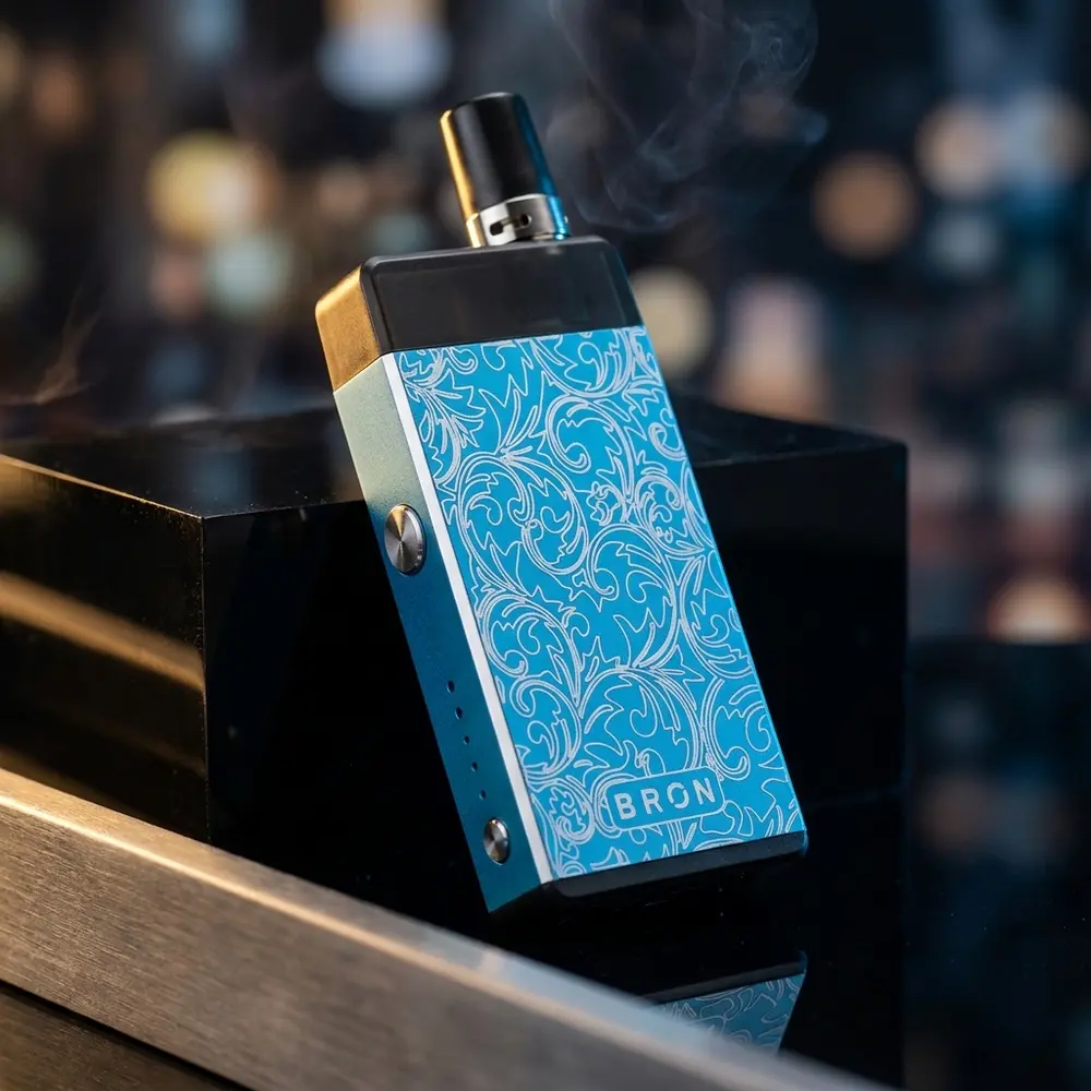 Kit Pod Bron CoilArt sobre base acrílica preta com gravação em metal e iluminação dourada e azul - Vapor Gringo